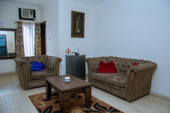 A living room with two sofas, a coffee table, and a small cabinet. - Zoey International Hotels Ltd (Owerri)