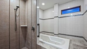 A bathroom with a walk-in shower, a bathtub, and a window. - Spacious 6-bedroom hilltop cabin in tranquil Oracle (Oracle)