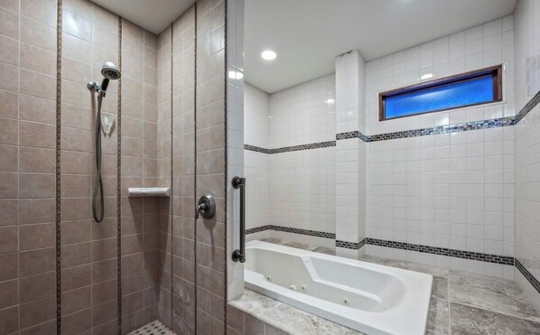 A bathroom with a walk-in shower, a bathtub, and a window. - Spacious 6-bedroom hilltop cabin in tranquil Oracle (Oracle)