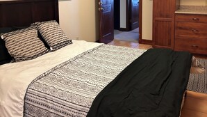 A bedroom with a bed, wooden headboard, and a wardrobe. - Spacious 6-bedroom hilltop cabin in tranquil Oracle (Oracle)