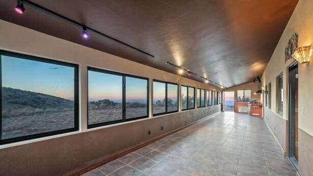 A long corridor with large windows offering views of a desert landscape. - Spacious 6-bedroom hilltop cabin in tranquil Oracle (Oracle)