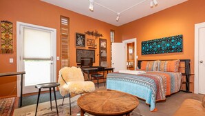 A cozy room with a bed, a chair, a desk, and a TV. - Boho Studio on 8th Ave West | Queen Anne, Seattle Near Stadium (Seattle)