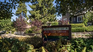 A sign for Queen Anne Boulevard, Seattle Historic Landmark, surrounded by lush greenery and trees. - Boho Studio on 8th Ave West | Queen Anne, Seattle Near Stadium (Seattle)