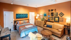 A bedroom with a bed, a sofa, a coffee table, a rug, and a dresser. - Boho Studio on 8th Ave West | Queen Anne, Seattle Near Stadium (Seattle)