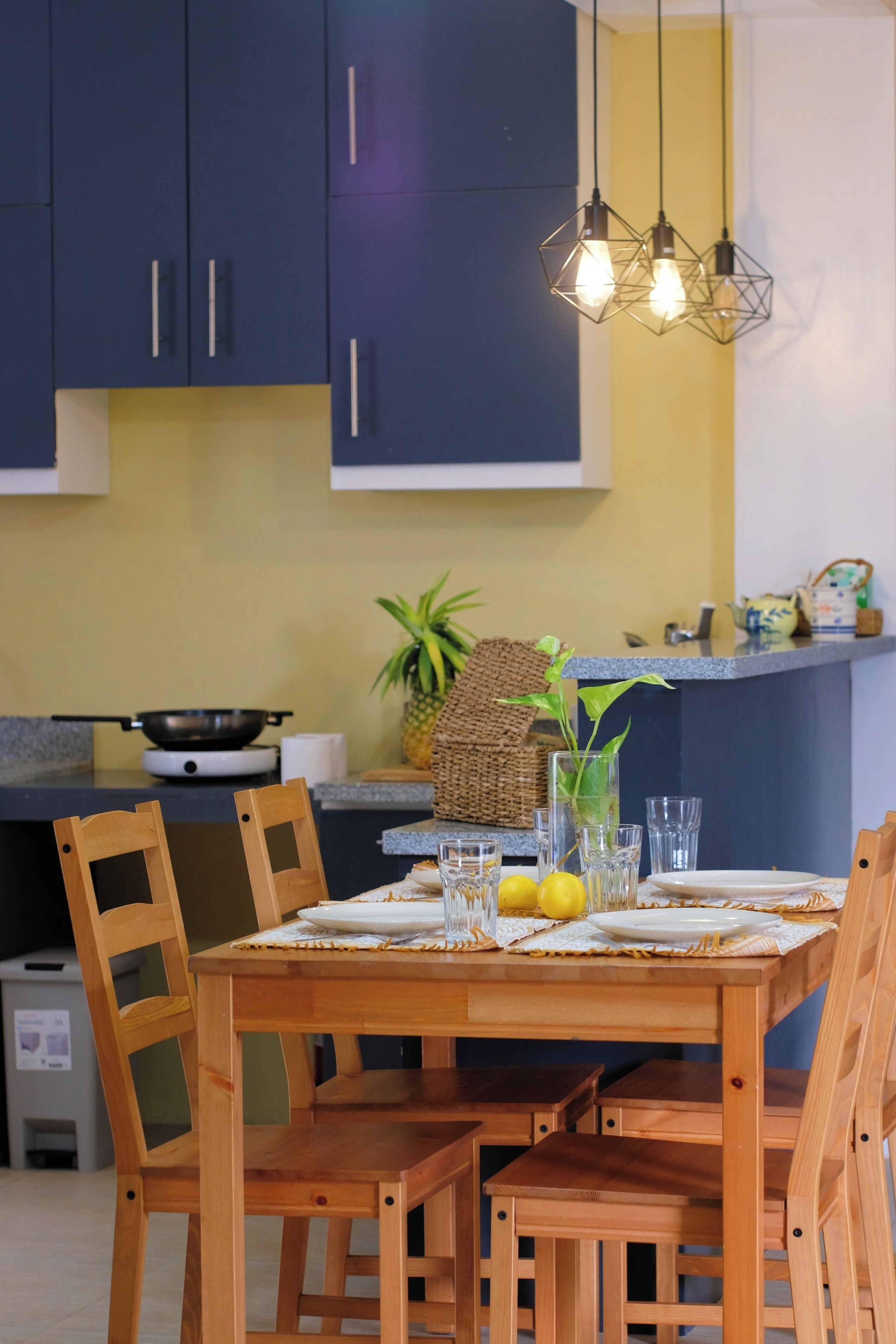 A dining area with a wooden table, chairs, and a kitchen in the background.