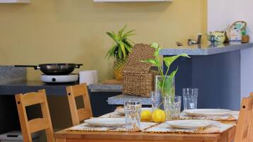 A dining area with a wooden table, chairs, and a kitchen in the background.