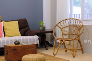 A room with a sofa, a wicker chair, a small table with a plant, and a wooden chest of drawers. - 2BR Laid Back Apartment, Near Beach (San Fernando)