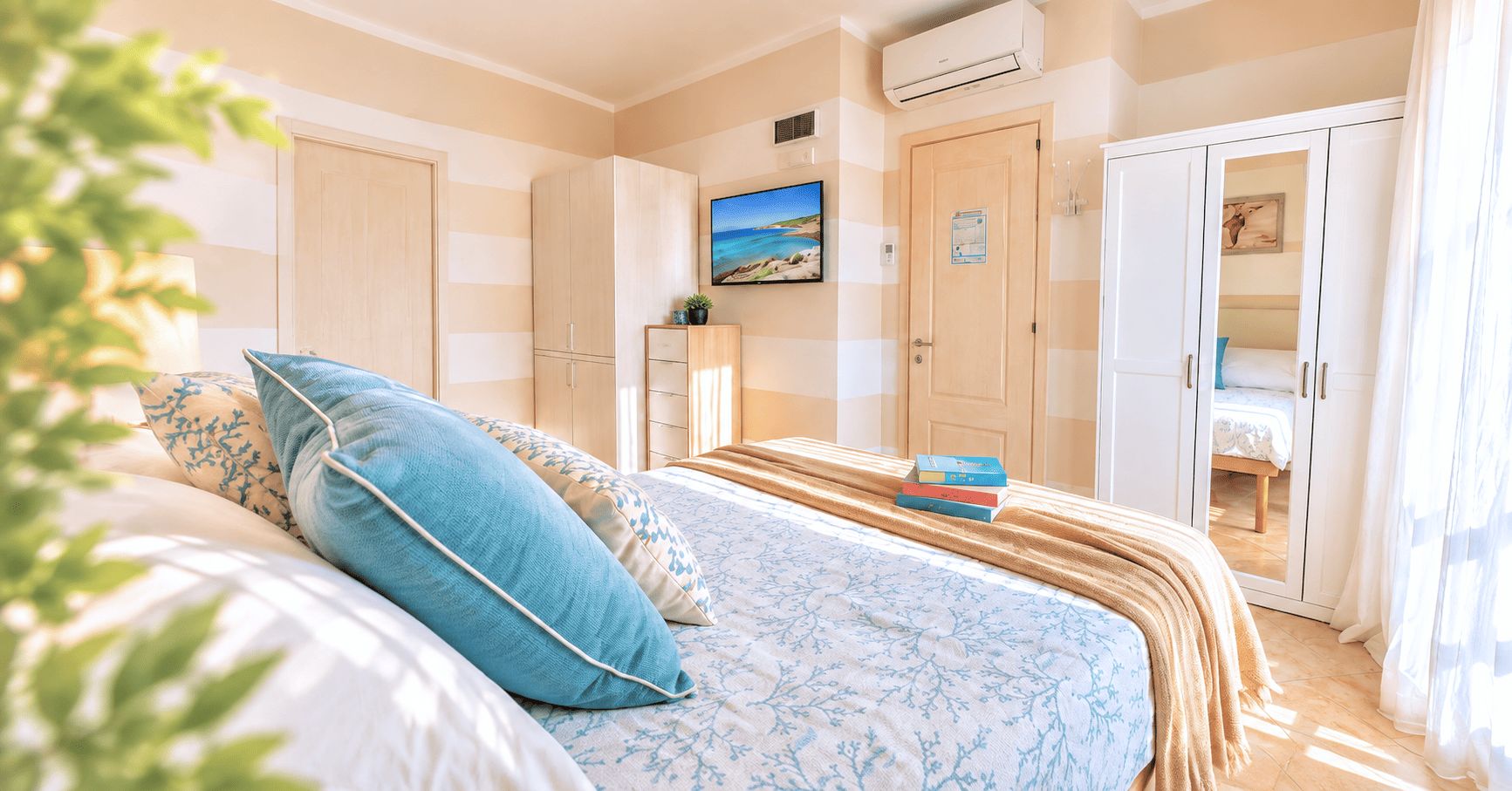A bedroom with a bed, a wardrobe, a television, and a door leading to another room.