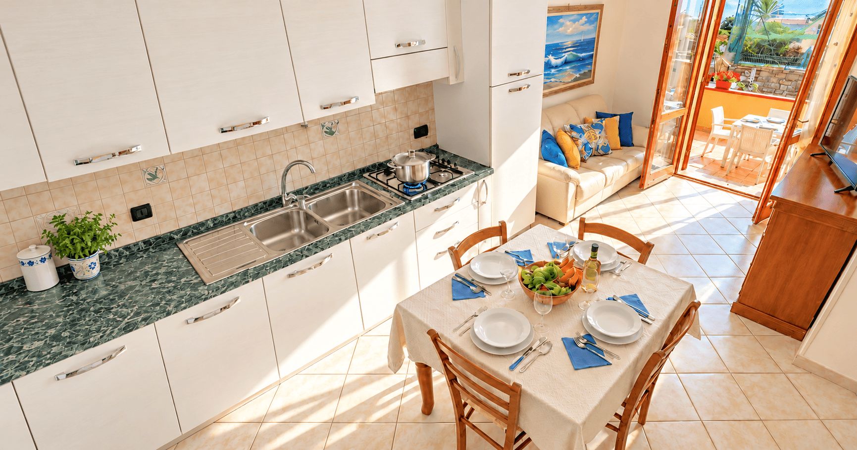 Una cocina moderna con comedor, vistas al exterior y un balcón con mesa lista para comer.