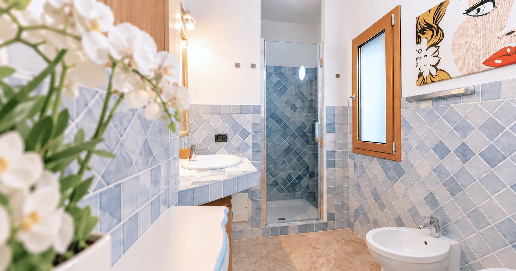 Ein Badezimmer mit Dusche, zwei Waschbecken und Toilette.