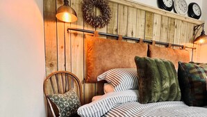 A bedroom with a wooden headboard, a star decoration, a wreath, and three clocks. - Family Bungalow, Mountain Views, Pets Welcome (Pontsticill)