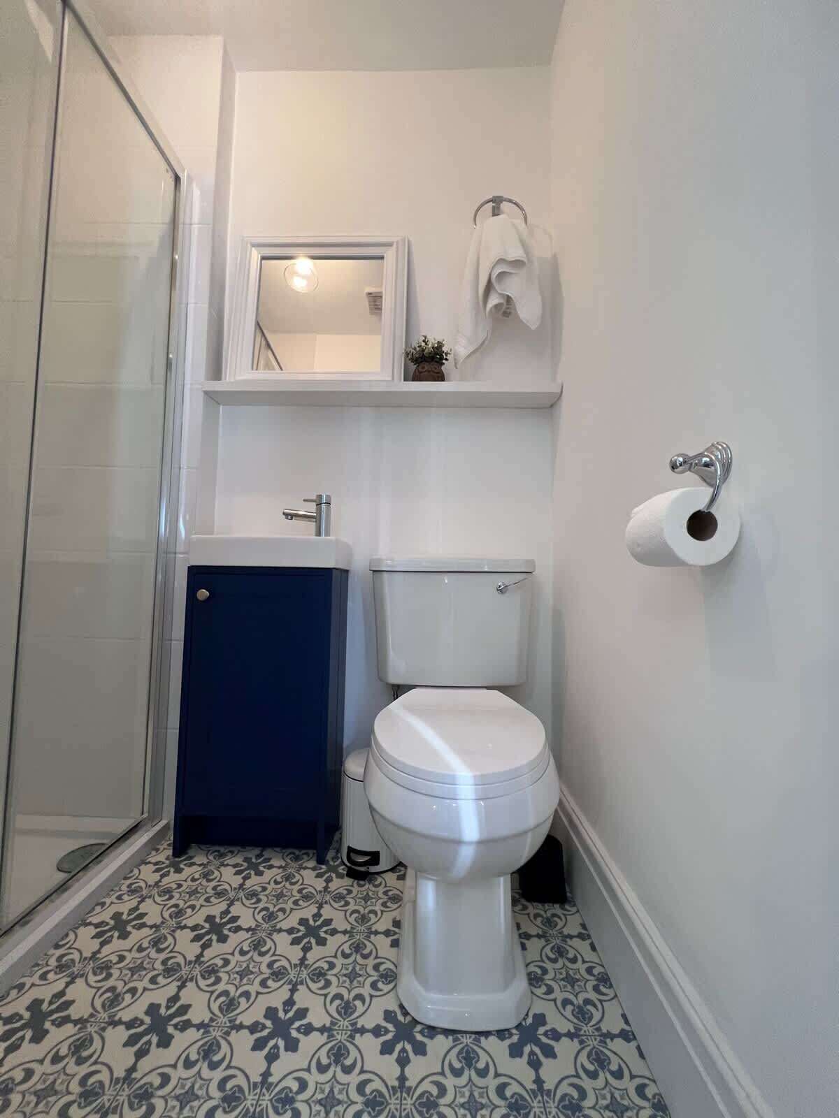 Une salle de bain avec des toilettes, un lavabo et une douche.