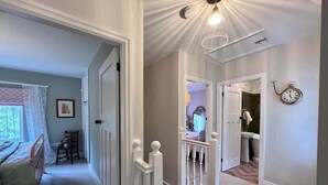 Ein Flur mit einer Treppe, die zu einem Schlafzimmer und Badezimmer führt.