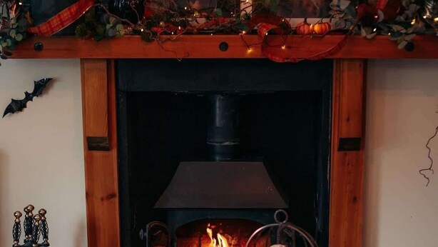 A cozy room with a fireplace, a wooden mantel, and a table set with food and drinks. - Charming Cottage w/ Valley Views & BBQ Hut (Pontsticill)