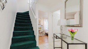 A staircase with green carpet leading to a room with a desk and a mirror. - 3BR Tower Bridge Parking WiFi (London)
