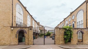 A brick building with a gated entrance, arched windows, and a sign reading "MELFOUR COURT". - 3BR Tower Bridge Parking WiFi (London)