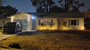Une maison à deux étages avec un garage, une allée et une pelouse.