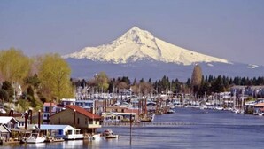 A marina with boats docked, a mountain in the background, and buildings along the waterfront. - Modern Studio in Terrific Portland with AC, WiFi (Portland)