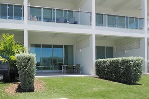 A modern building with a flat roof, large glass windows, and a covered outdoor seating area.