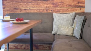 Uma sala de estar moderna com parede de madeira, um sofá marrom, uma mesa de centro de madeira e um prato com comida.