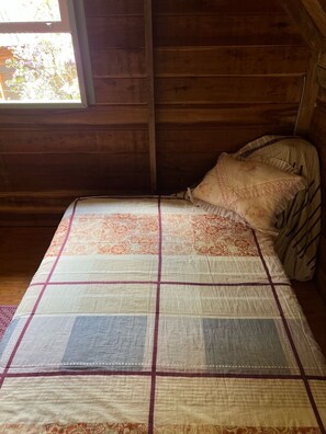 A wooden cabin room with a bed, a window, and a wooden ceiling. - Comfort of nature (Aguas mornas)