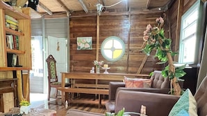 A rustic wooden interior with a brown leather sofa, a wooden coffee table, and a bookshelf. - Comfort of nature (Aguas mornas)