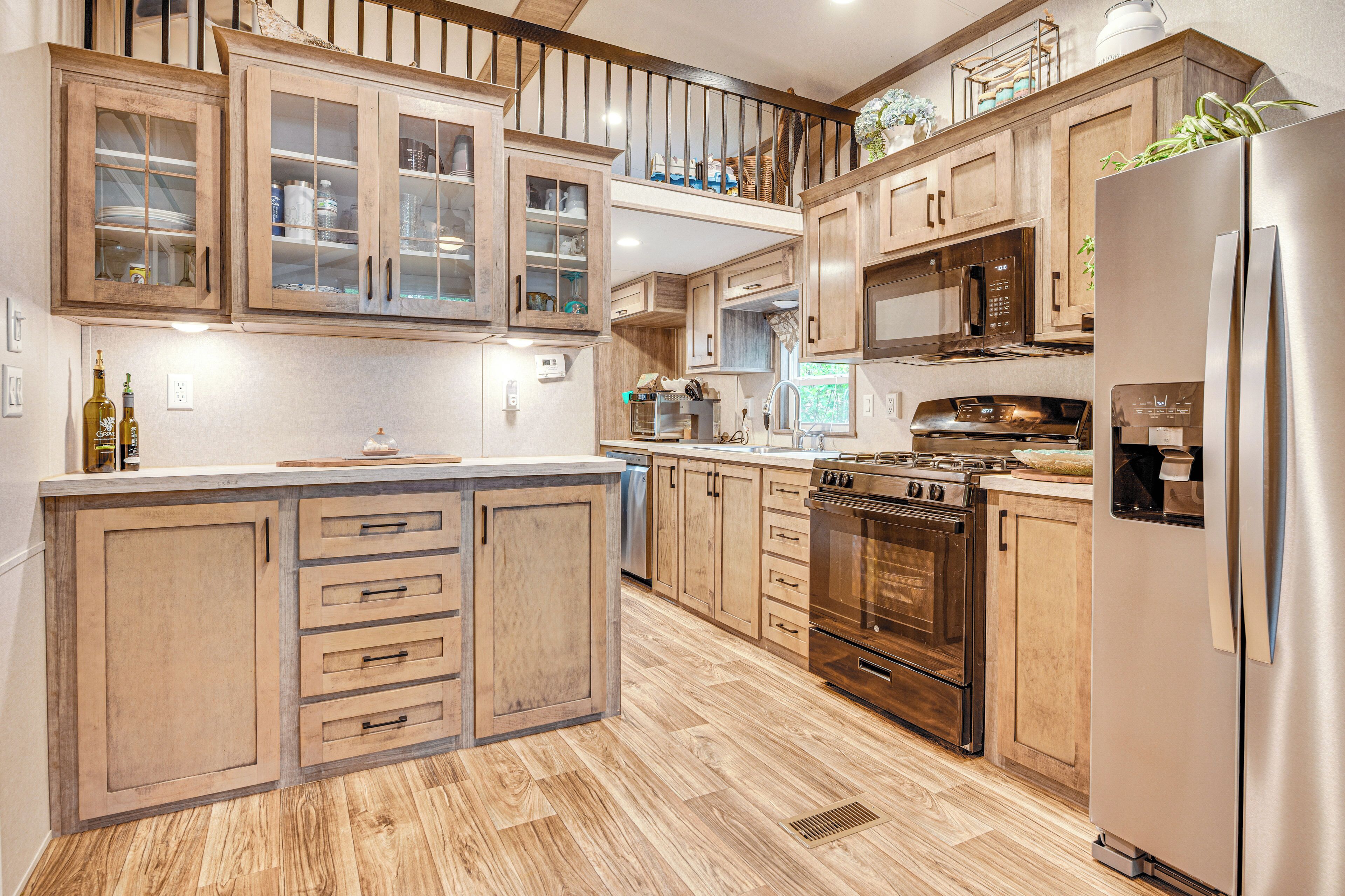A spacious kitchen with wooden cabinets, a stainless steel refrigerator, and a built-in oven.