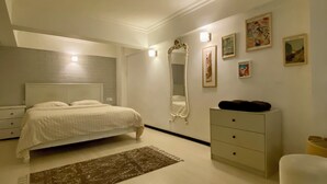 A bedroom with a bed, dresser, nightstand, mirror, and artwork on the wall. - M4 Istiklal Spacious and Central 1+1 Apartment (Istanbul)