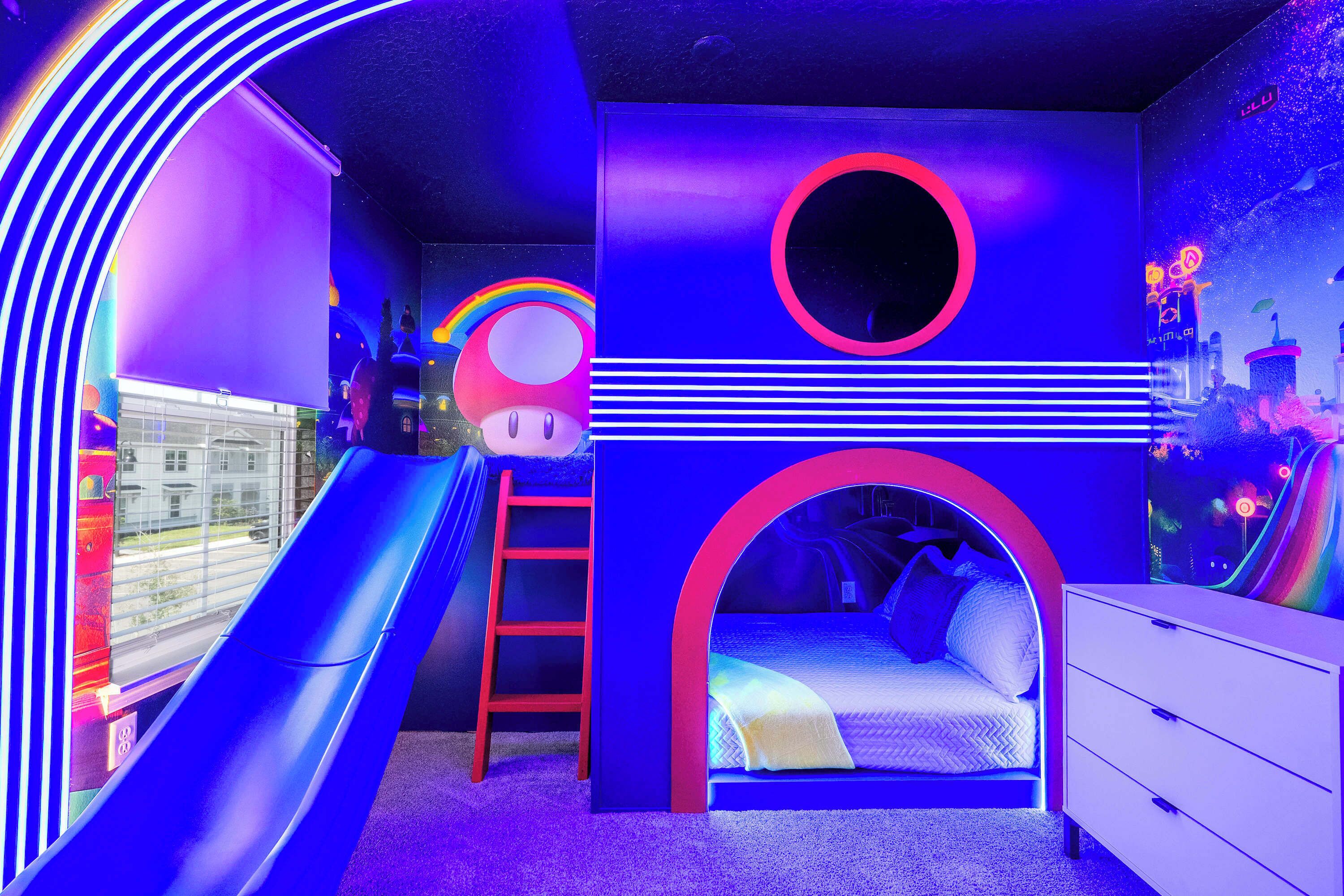 Un cuarto de juegos infantil con un tobogán, una escalera, una cama y un aparador.