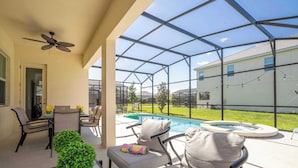A covered patio with a pool, outdoor furniture, and a ceiling fan. - Family Friendly 12Bd W Jacuzzi Veranda Palms 4401 (Kissimmee)