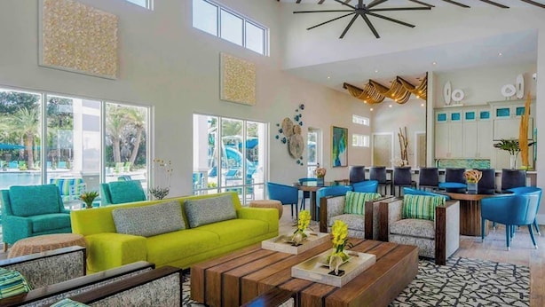 A spacious lobby with a bright green sofa, wooden coffee table, and a modern ceiling design. - Family Friendly 12Bd W Jacuzzi Veranda Palms 4401 (Kissimmee)