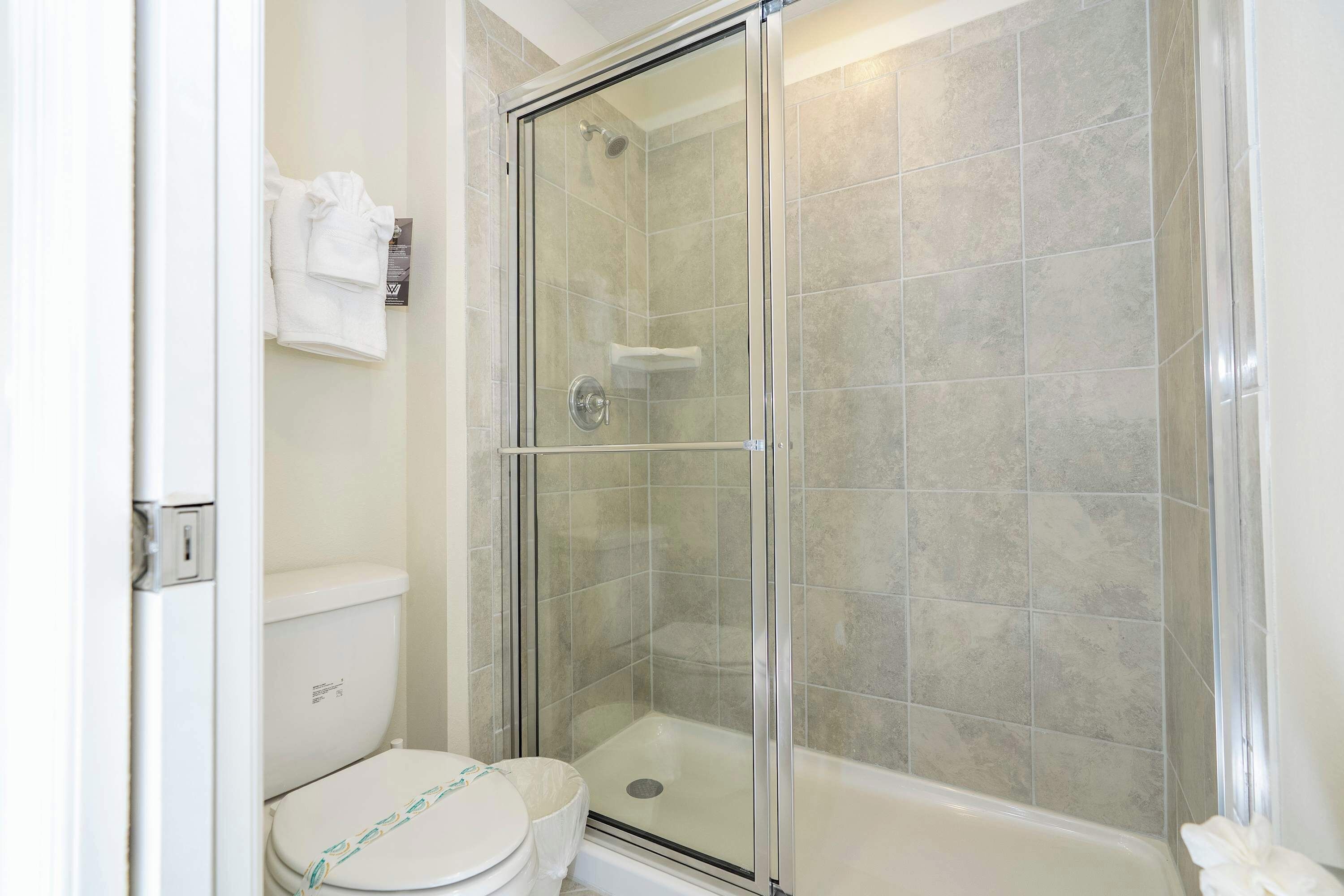 Ein Badezimmer mit Duschkabine, Toilette und Badewanne.