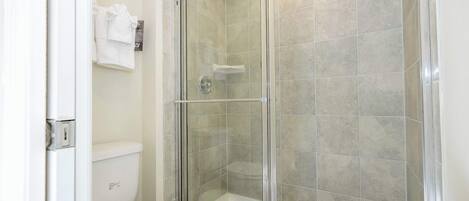Ein Badezimmer mit Duschkabine, Toilette und Badewanne.