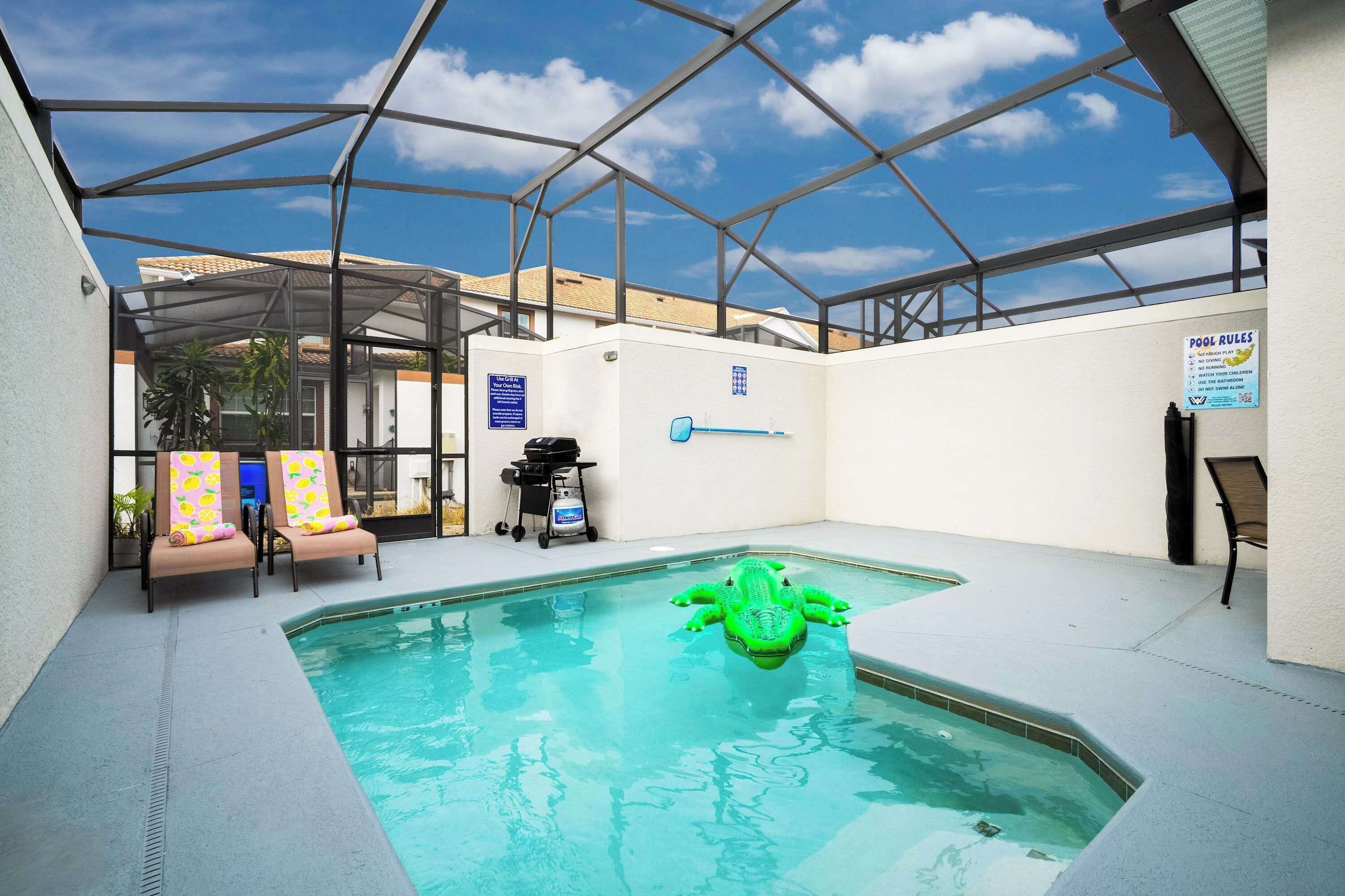 A pool area with a glass enclosure, lounge chairs, and a pool rule sign.