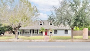 A single-story house with a red door, a small porch, and a mailbox. - Spacious House by TopGolf Pharr (Pharr)