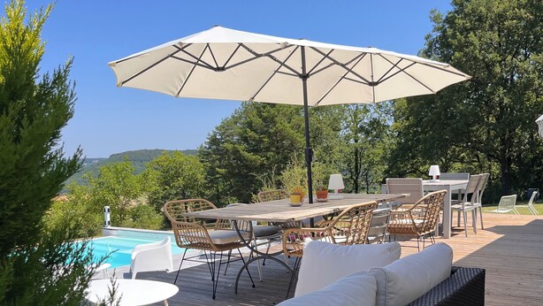 Eine Terrasse mit Gartenmöbeln, einem Pool und Blick auf die Landschaft.