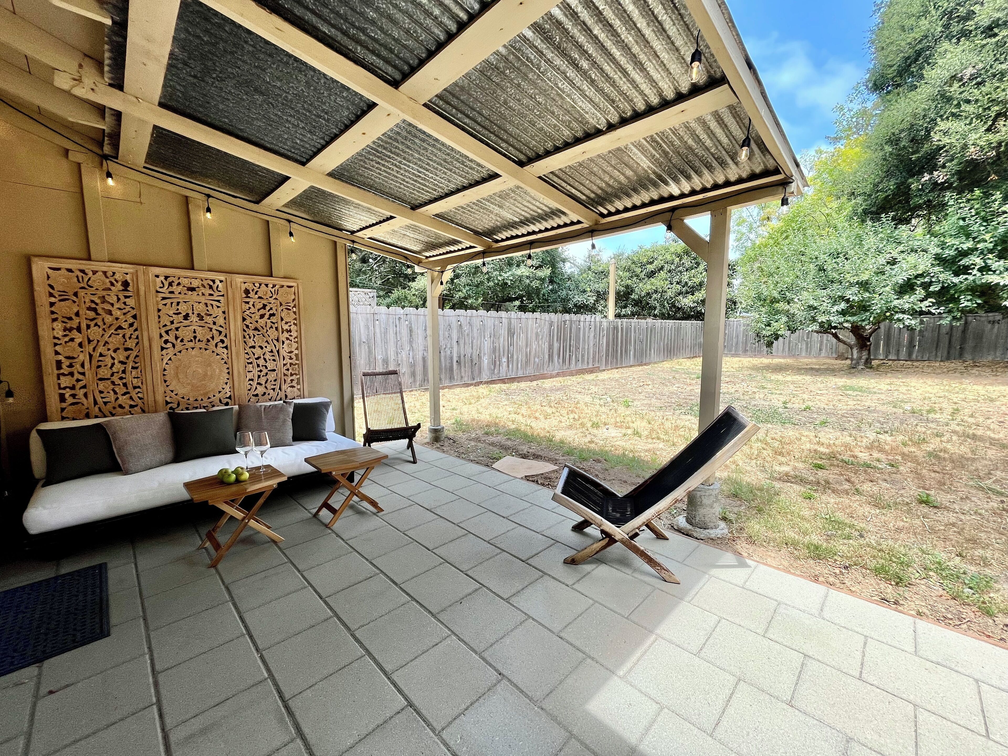 An outdoor patio with a sofa, chairs, and a table.