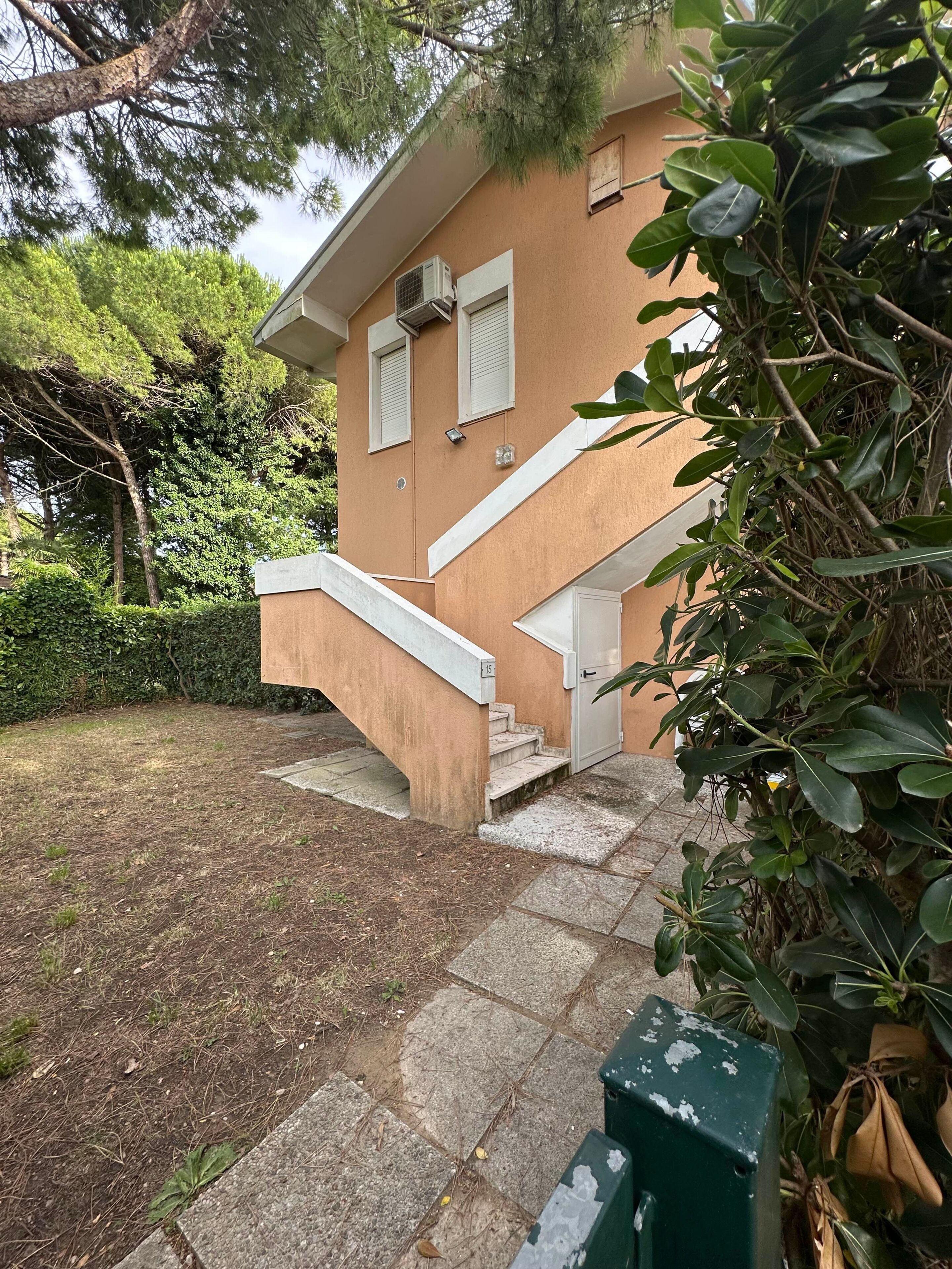 Un edificio de dos plantas con una escalera de piedra que lleva a la entrada.