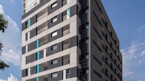 A multi-story building with a modern architectural design, featuring balconies and a gated entrance. - Spin Stays (São Paulo)