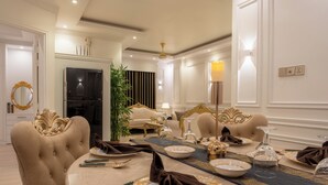 A dining area with a round table set for four, surrounded by plush chairs. - The Versailles Suite A Designer Home in Dhaka (Dhaka)