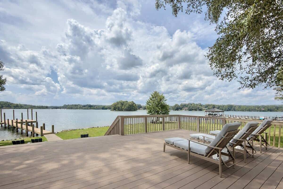 Eine Holzterrasse mit Liegestühlen und Blick auf einen See.