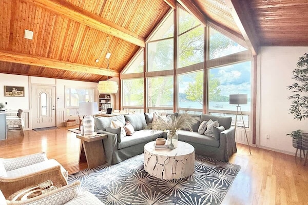 Large open concept room with original cathedral wood ceilings and 2-story windows with 180 degree views of Lake Norman
