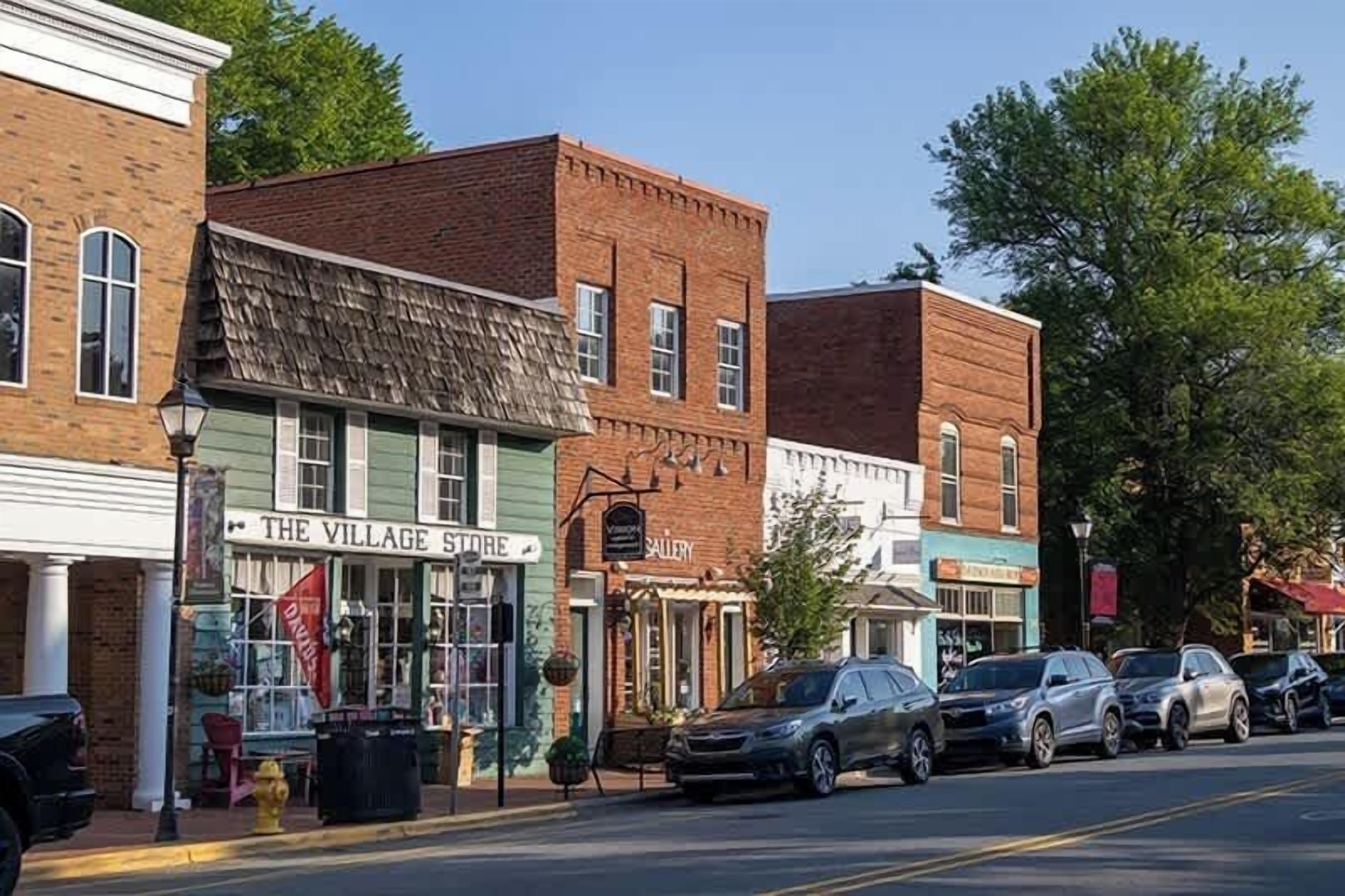 A street with buildings, including a store named 'The Village Store' and a gallery.