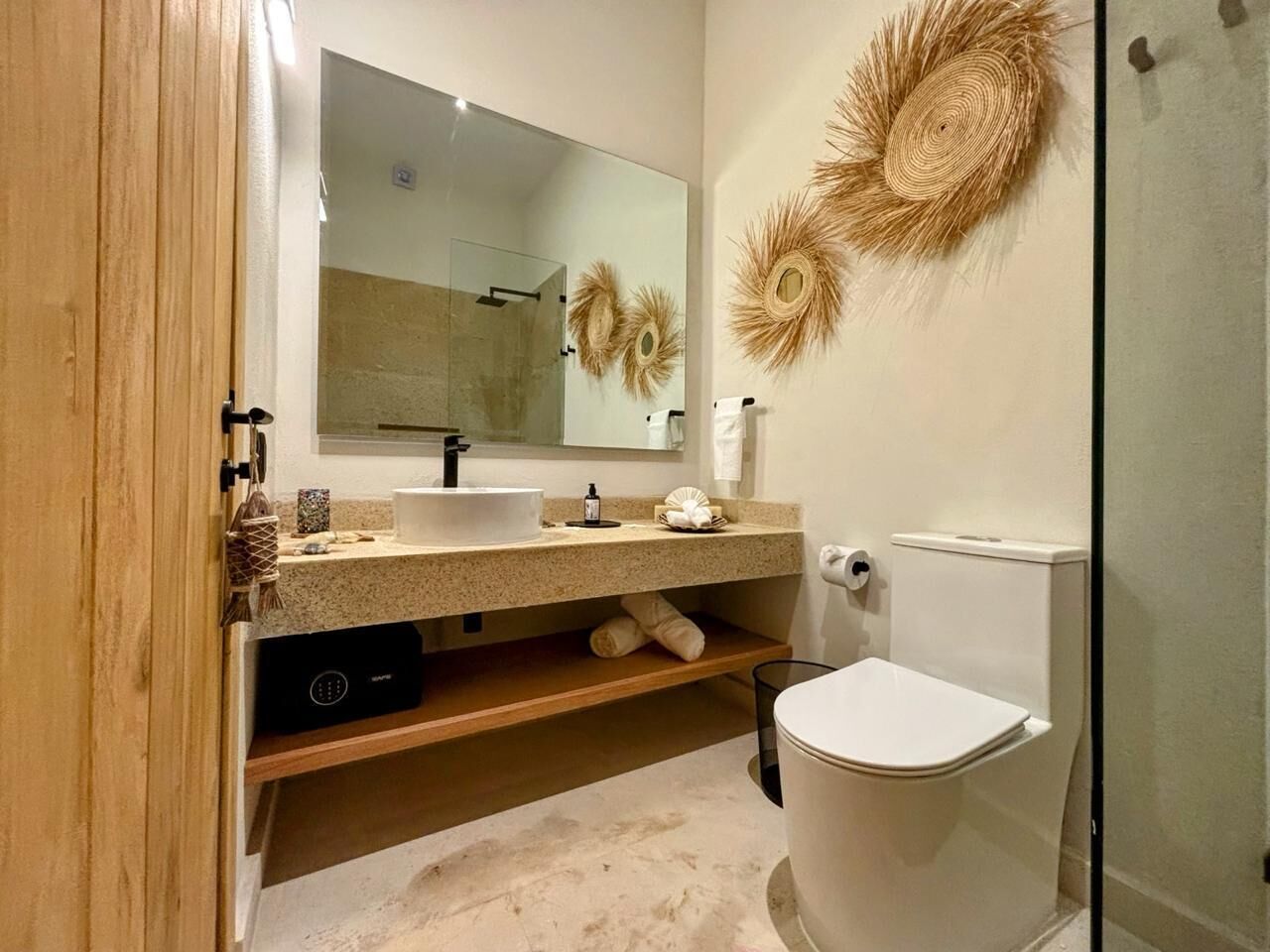 A modern bathroom with a glass shower enclosure, a sink with a mirror, and a toilet.