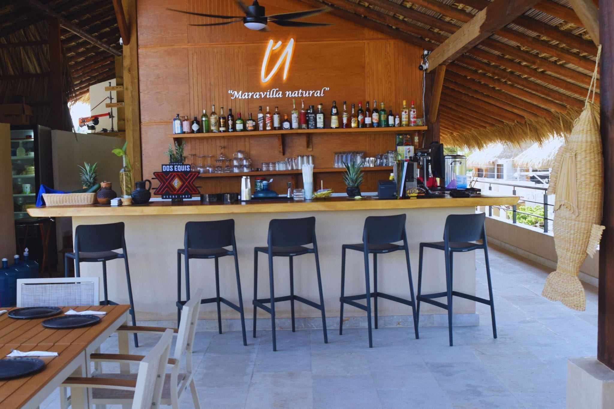 A bar area with a wooden ceiling and a sign reading "Maravilla natural".