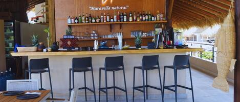A bar area with a wooden ceiling and a sign reading "Maravilla natural".