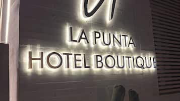 Un letrero para "LA PUNTA HOTEL BOUTIQUE" con letras iluminadas.