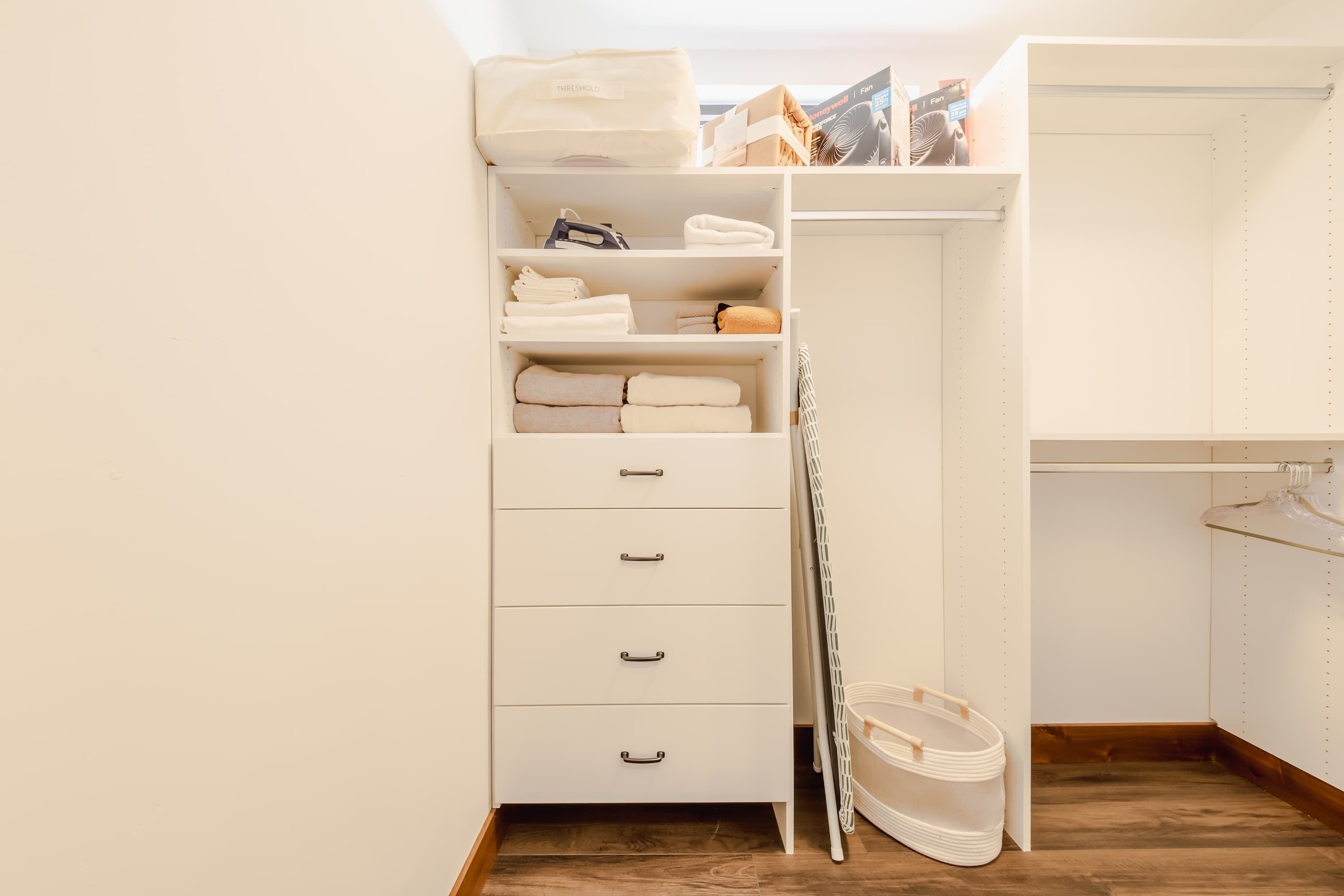A white closet with shelves, drawers, and hanging space.