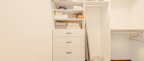 A white closet with shelves, drawers, and hanging space.