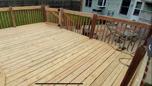A wooden deck with a railing, surrounded by a wooden fence and a grassy yard. - Chic apartment in cool Huntington with AC, fitness room. Private bathroom. (Huntington)